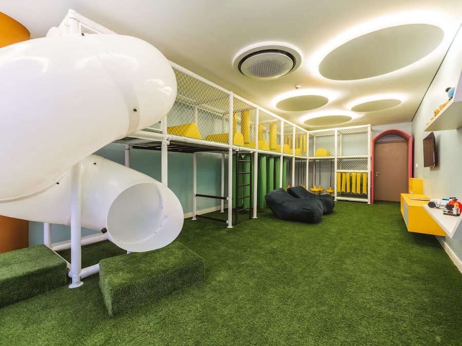 A children's play area with a slide, climbing steps, and soft play furniture.