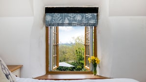 Une chambre avec une fenêtre donnant sur un jardin.
