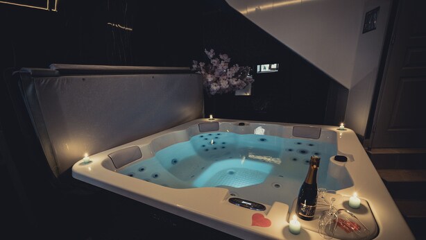 A hot tub with candles, a bottle, and a heart-shaped decoration. - LOFT with private jacuzzi, CENTRE VILLE PONTOISE (Pontoise)