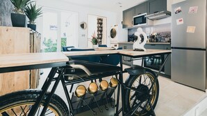 A modern kitchen with a bicycle rack, a refrigerator, and a microwave. - LOFT with private jacuzzi, CENTRE VILLE PONTOISE (Pontoise)
