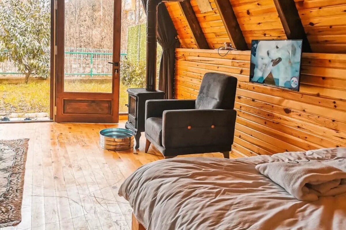 Una habitación acogedora con una cama, una silla, una mesita y una chimenea.