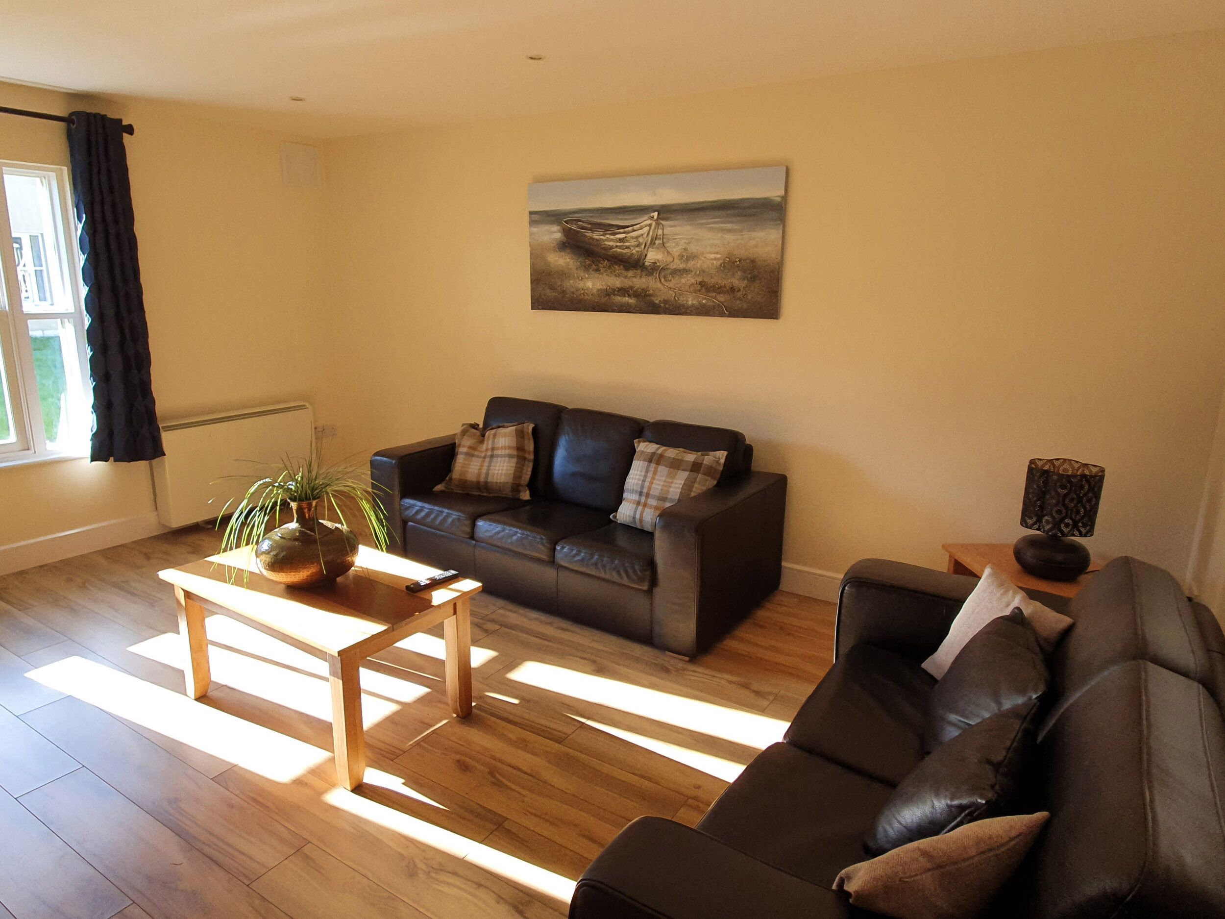 A living room with a sofa, a coffee table, and a painting on the wall.