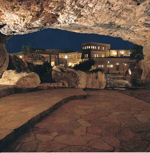 Experience the unique architecture of this multi-level hotel, set amidst a natural landscape with a pathway leading to the entrance.