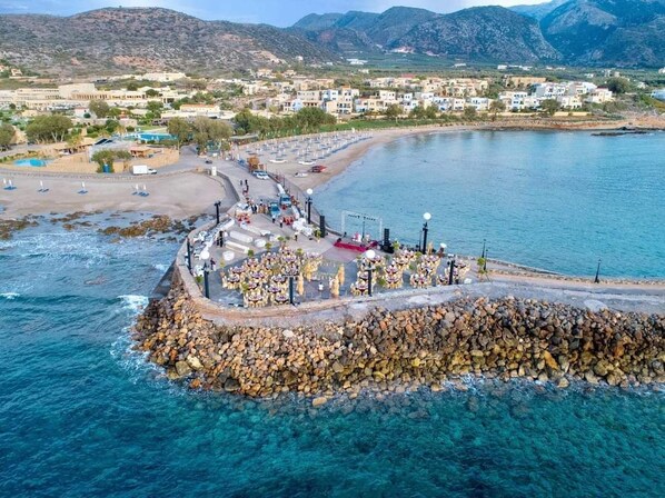 Stroll along the breakwater, taking in the views of the clear blue sea and surrounding mountains.