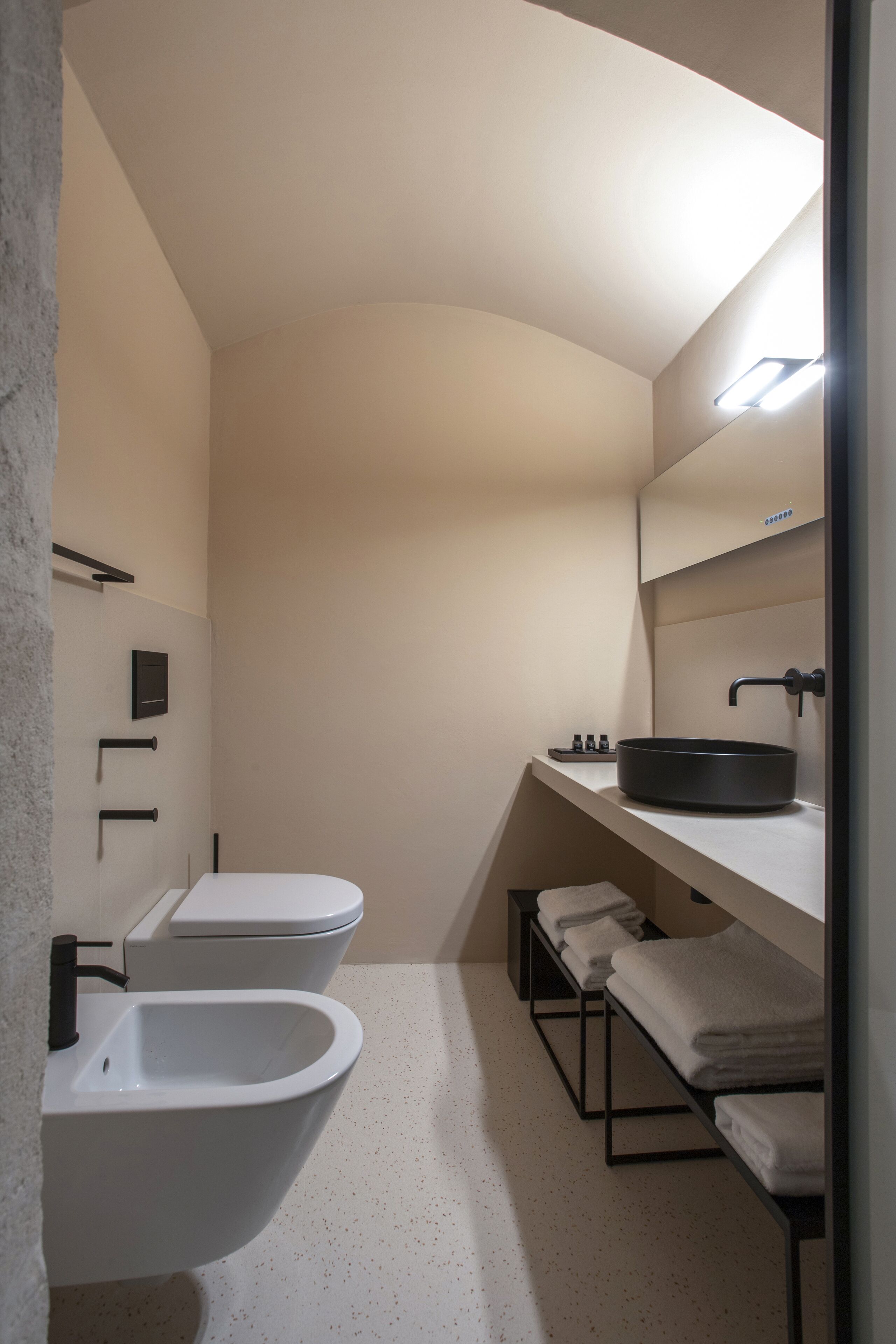 Un bagno moderno con una vasca freestanding, un water e un lavabo con specchio sopra.