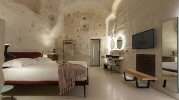 A modern hotel room with a large bed, a bench, a vanity with a mirror, and a wall-mounted sink.