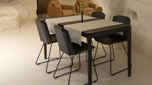 Un comedor con una mesa y sillas, un sofá y una planta.