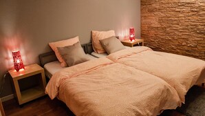 A double bed with a beige patterned bedspread, two pillows, and two bedside tables with red lamps. - On your terrace at the foot of an oak tree, feel the Alsace's vibes ! (Barr)