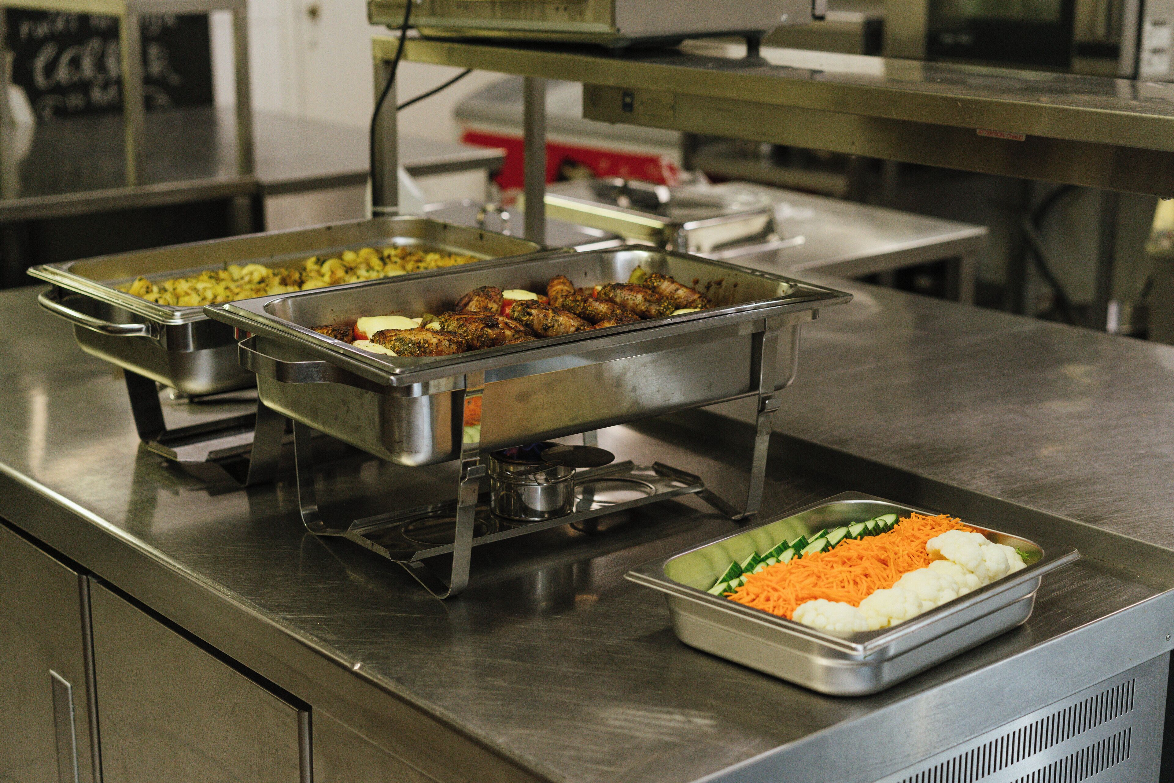 A buffet with various food items including meats, vegetables, and rice.