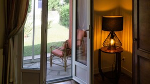 An open door leading to a patio with a chair and a lamp.