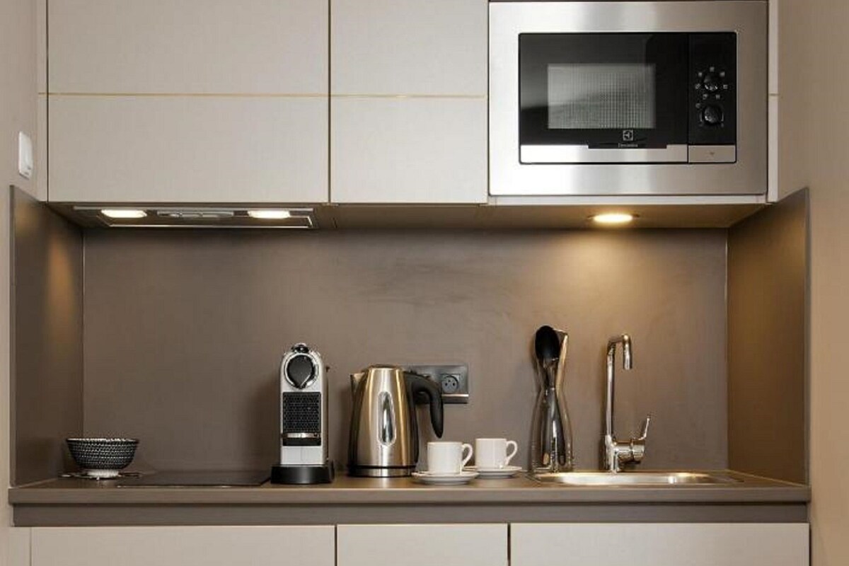 Una cocina moderna equipada con microondas, hervidor de agua y cafetera.