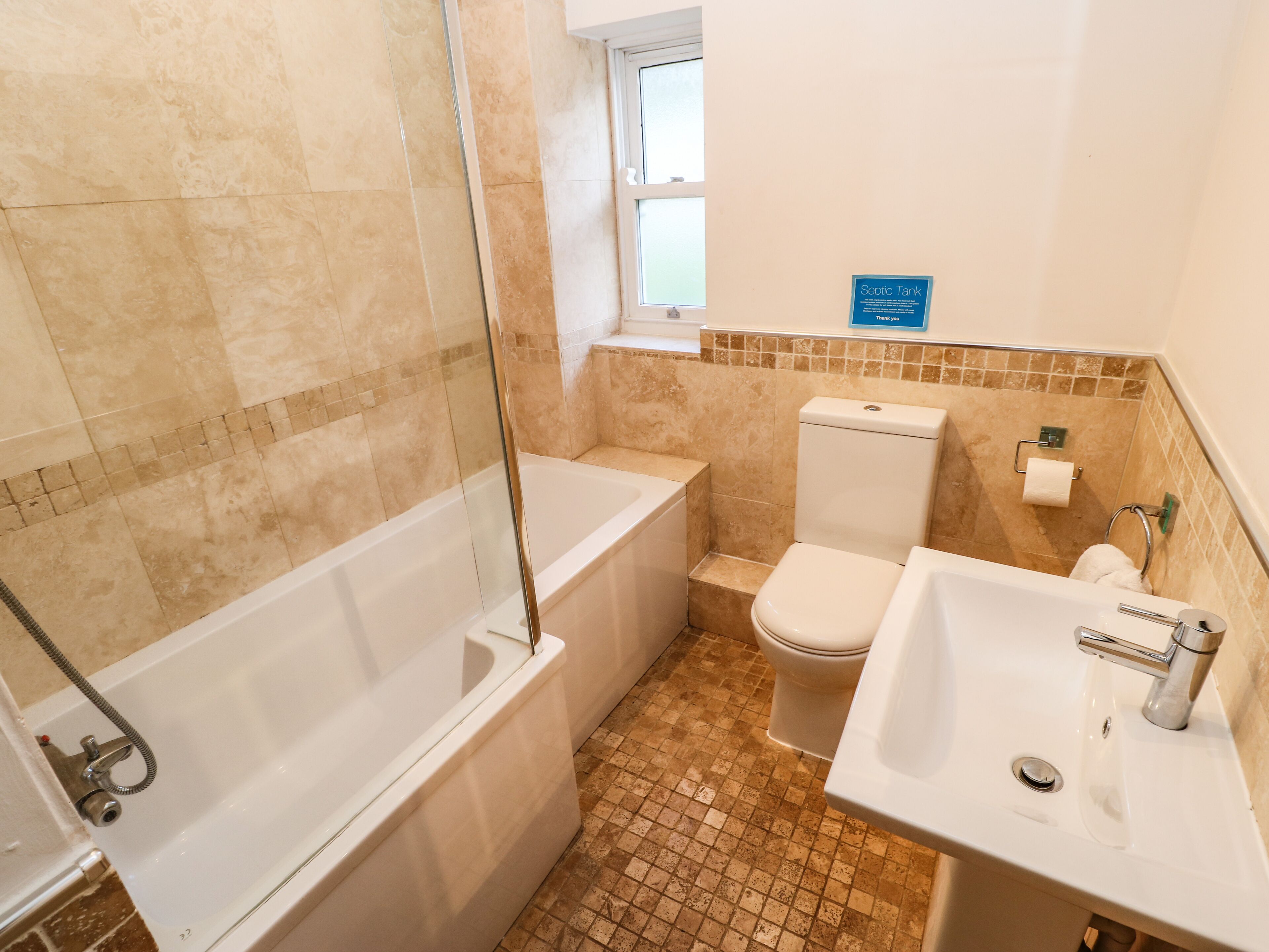 A bathroom with a bathtub, toilet, and sink.