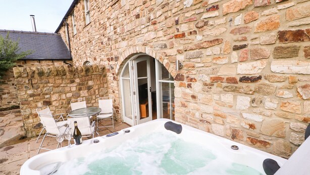 A stone building with a hot tub in the foreground. - Brancepeth (Bishop Auckland)