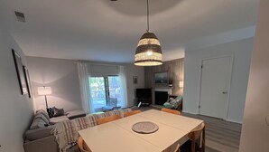 A modern living room with a dining table, sofa, and TV.
