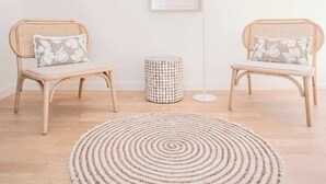 A minimalist room with two wicker chairs, a round rug, a lamp, and a framed picture on the wall. - Liiiving in Porto - City Design Apartment C (Porto)