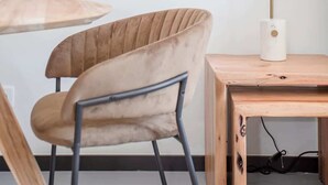 A modern room with a round wooden table, a beige upholstered chair, a floor lamp, and two framed artworks on the wall. - Liiiving in Porto - City Design Studio II (Porto)