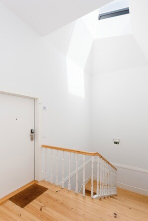 Stairs lead to an upper level with a skylight above.