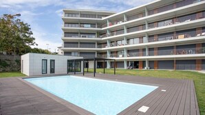 A modern multi-story building with a swimming pool in the foreground. - Liiiving in Porto - Dragão Pool View (Porto)
