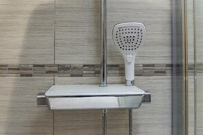 A showerhead mounted on a wall with a tiled backsplash. - Harry s - 2 Bedroom Holiday Home - Tenby (Tenby)