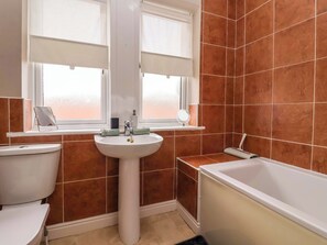 A bathroom with a white sink, toilet, and bathtub. There are two windows with blinds, a mirror, and a towel rack. - 8 Williamson Drive (Ripon)