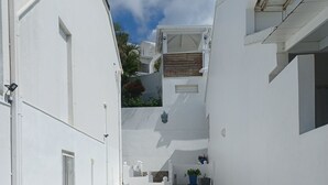 A narrow, white-walled alley with stone steps leading to a higher level. - 5 min from Orient Bay-magical view (Collectivity of Saint Martin)