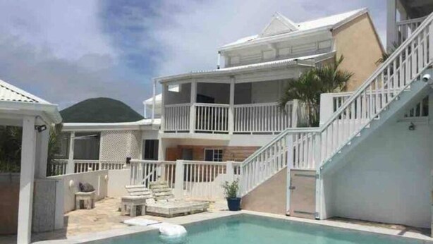 A two-story house with a swimming pool, a covered patio, and a staircase leading to the upper level. - 5 min from Orient Bay-magical view (Collectivity of Saint Martin)