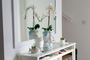A white console table with a mirror above it, reflecting white orchids and a white vase with a blue design. - Villa Fedora, with private pool, between Sorrento and Amalfi Coast (Massa Lubrense)