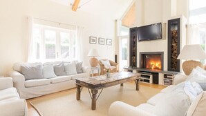 A living room with a fireplace, a sofa, a coffee table, and a television.