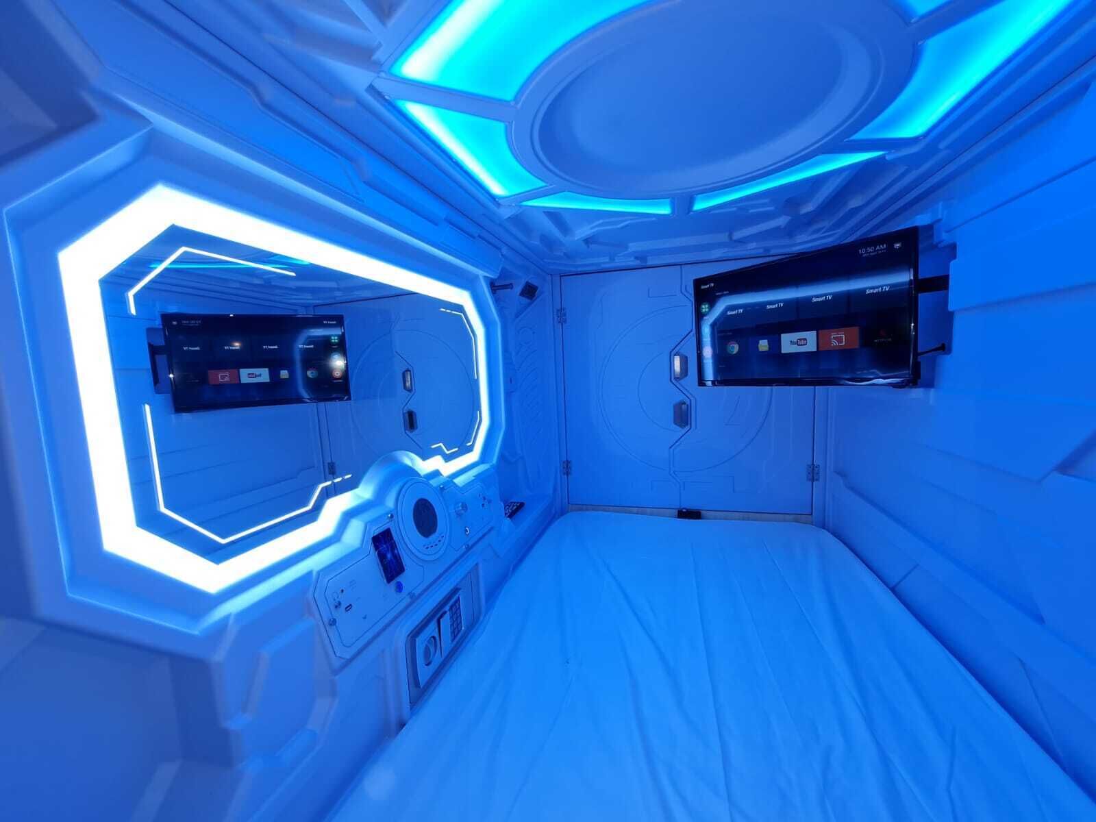 Ein Zimmer mit einem Bett, einer Steuerung und einem an der Wand befestigten Fernseher.