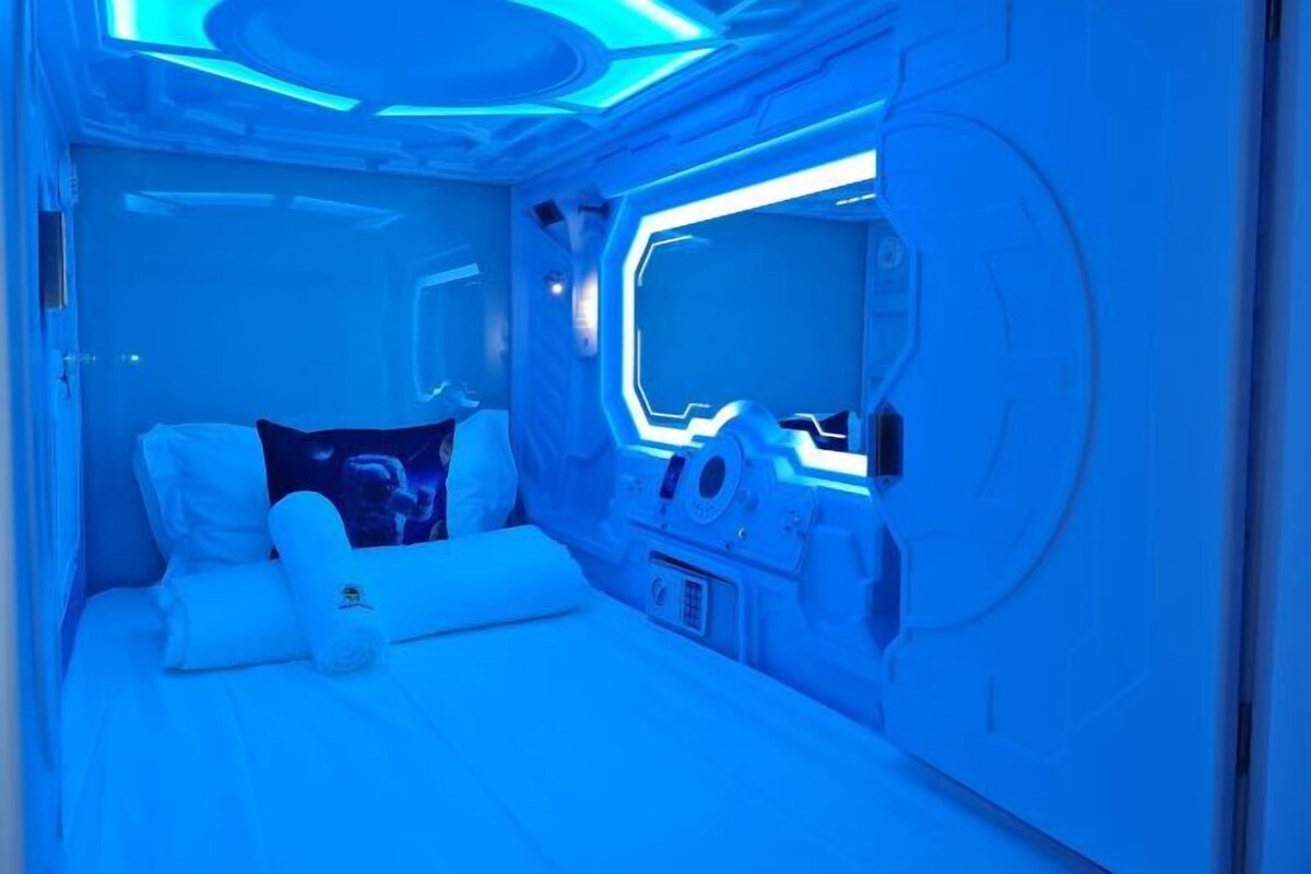 Una habitación con una cama, almohadas y un panel de control.