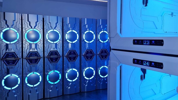 Une rangée de casiers futuristes et ultramodernes, dotés de motifs circulaires bleus illuminés et d’étiquettes numérotées.
