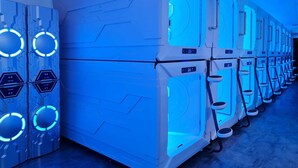 Une rangée de grandes machines blanches au design futuriste, dotées de lumières bleues et d’étiquettes numérotées.