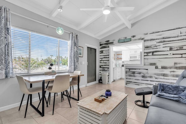 A modern kitchen with white cabinets, a black countertop, and a view of the outdoors. - Island Breeze Condo's (Englewood)
