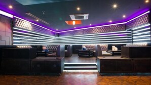 A modern lounge with leather seating, a patterned wall, and a geometric floor design. - York International Hotel (Dubai)