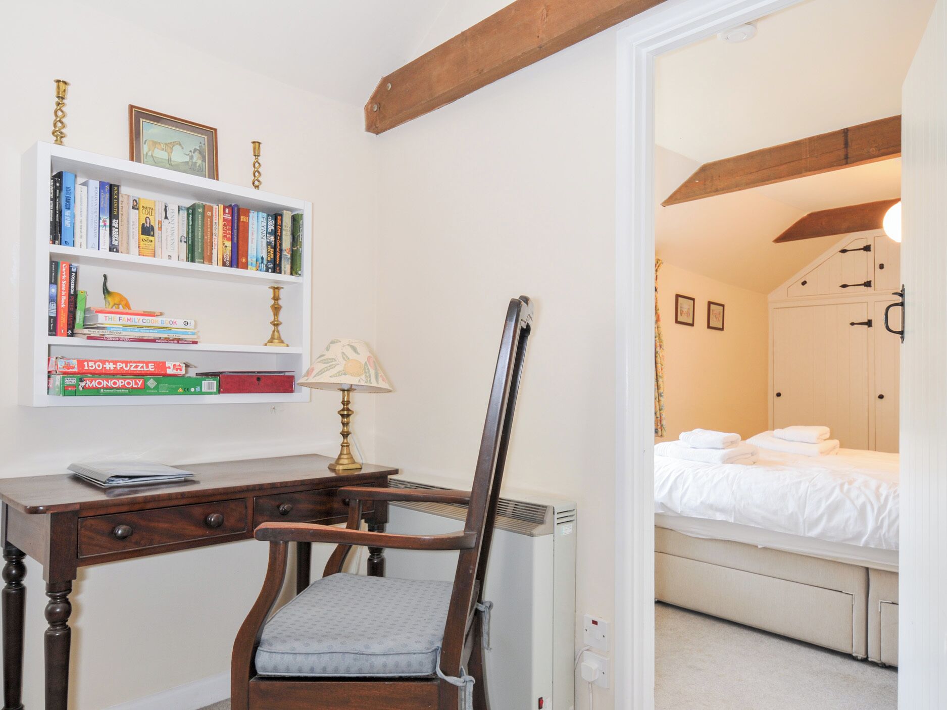 A bedroom with a bed, a bedside table, and a chair.