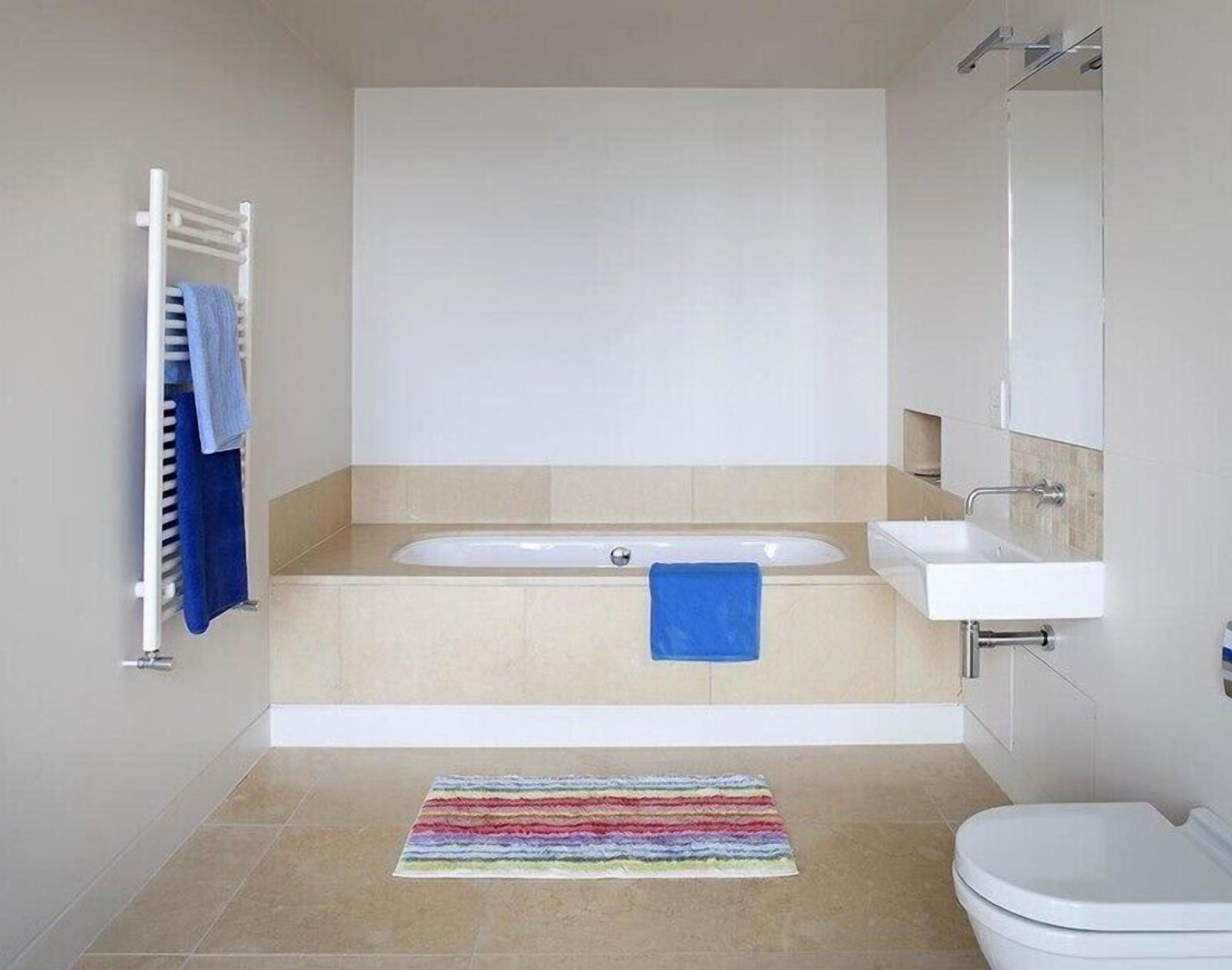 A modern bathroom with a bathtub, a sink, and a toilet.