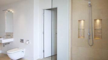 A modern bathroom with a toilet, sink, and shower.