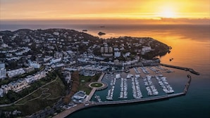 An aerial view of a coastal cityscape during sunset with a marina filled with boats. - Lovely Apartment Sleeps 6 Singles in Torquay (Torquay)