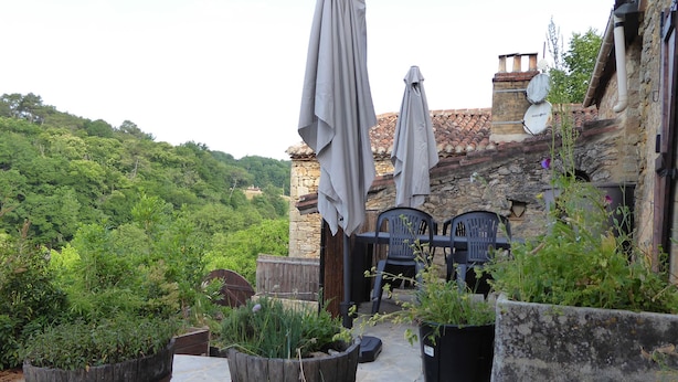 Un espace patio doté d’un sol en pierre, de mobilier d’extérieur et de plantes en pot.