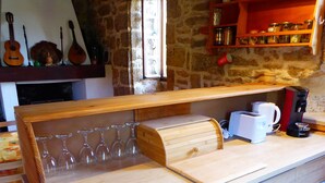 Un comptoir de cuisine avec un porte-bouteilles, une machine à café et un grille-pain.