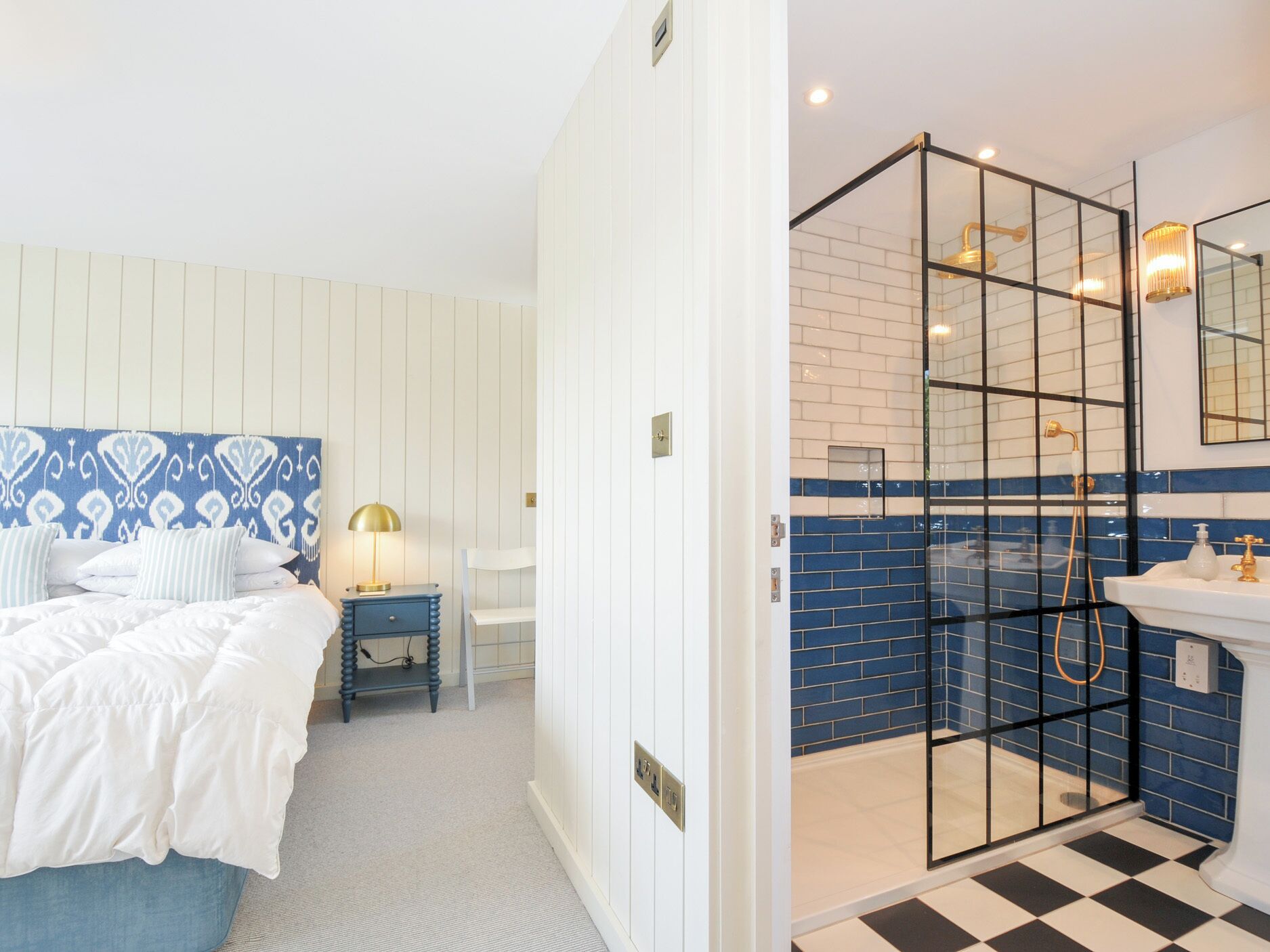 A bedroom with a bed, bedside table, and lamp.