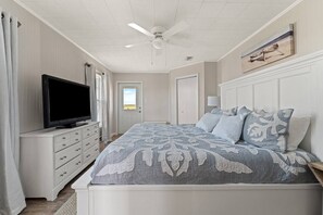 A bedroom with a bed, a television on a dresser, a ceiling fan, and a door leading outside. - Stunning Beach Views, Dogs Welcome/Family Friendly! (Gulf Shores)