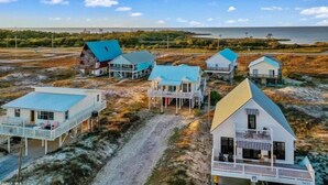 Il s'agit d'une propriété située sur la côte, comprenant plusieurs maisons dotées de structures surélevées et de terrasses, et offrant probablement une vue sur l'océan.
