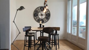 A dining area with a round wall clock, wooden chairs, a table, and a floor lamp. - 75 m2 # logia # parking # BESTOFBLO 4 # INSEAD (Fontainebleau)
