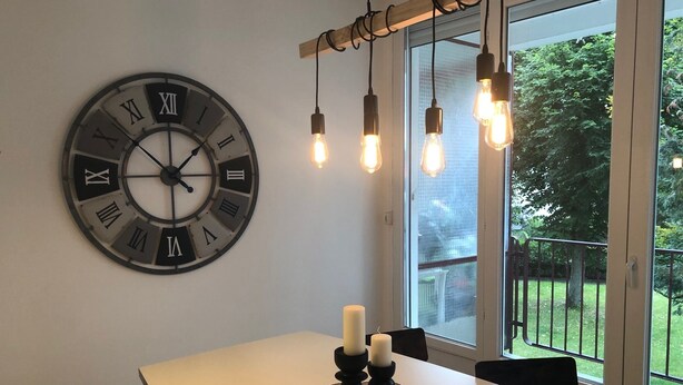 A dining area with a large wall clock, hanging light fixtures, and a view of the outdoors. - 75 m2 # logia # parking # BESTOFBLO 4 # INSEAD (Fontainebleau)