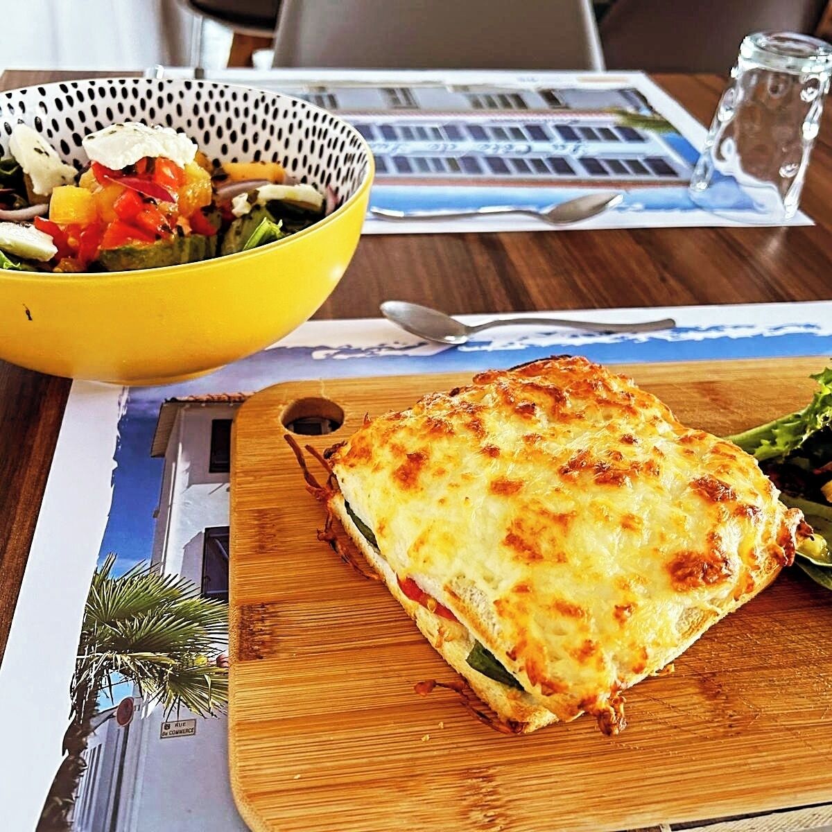 Una comida con un plato al horno y un bol de ensalada sobre una mesa de madera.