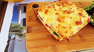 Una comida con un plato al horno y un bol de ensalada sobre una mesa de madera.