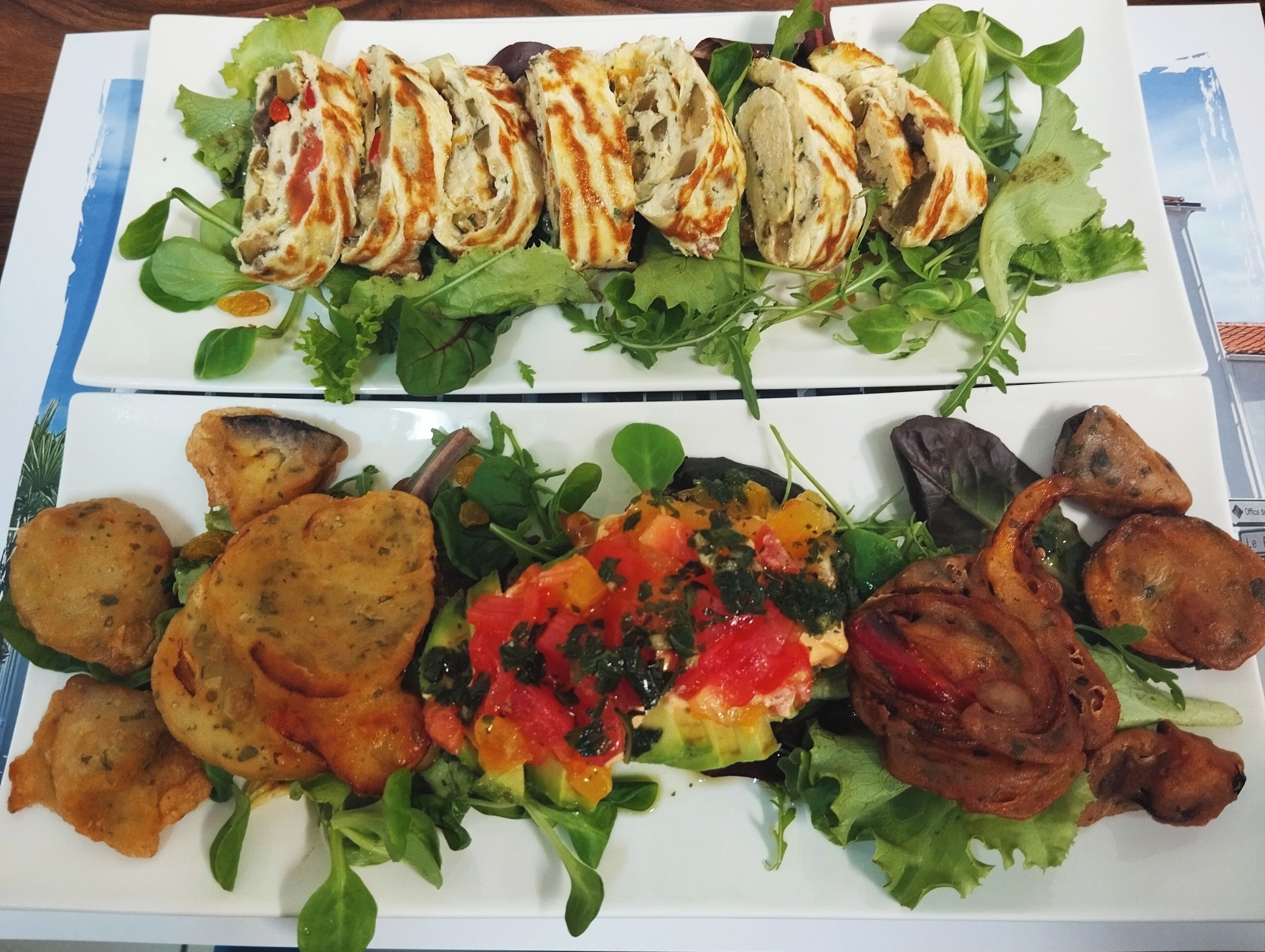 A meal with grilled chicken, vegetables, and bread on a white plate.