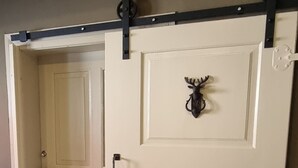 A sliding barn-style door with a decorative deer head, a sliding barn-style door with a decorative deer head, and a sliding barn-style door with a decorative deer head. - Lovingly furnished FeWo zum Hirschen (Herzberg am Harz)