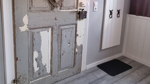 A hallway with a rustic door, a heart-shaped decoration, and a coat rack. - Lovingly furnished FeWo zum Hirschen (Herzberg am Harz)